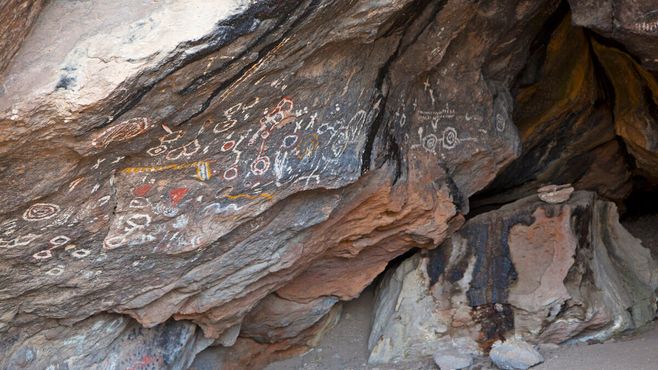 Пиктограммы разных цветов покрывают стены пещеры