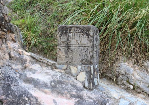 Резная каменная табличка у колодца Янаяку