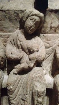 Одна из богинь кормит грудью ребёнка, олицетворяя деторождение
