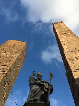 Святой Петроний, покровитель Болоньи, стоит перед башнями Гаризенда и Азинелли