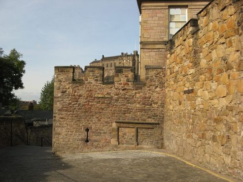 Остатки бастиона Флодденской стены XVI века (в центре) на фоне Эдинбургского замка и Телферова стена XVII века справа