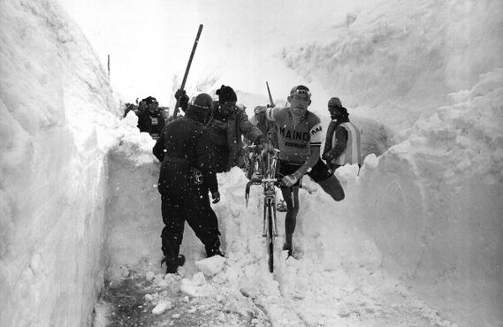 Итальянский велосипедист Альдо Мозер переносит велосипед через снег на "Джиро д'Италия" 1965 года