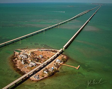 Вид с высоты птичьего полёта на остров Пиджин-Ки с частично разрушенным Морским железнодорожным мостом, идущим параллельно новому Семимильному мосту