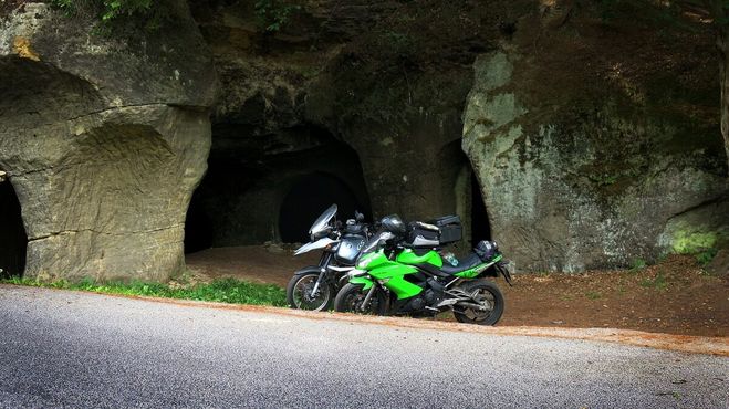 Пещера с припаркованным снаружи мотоциклом