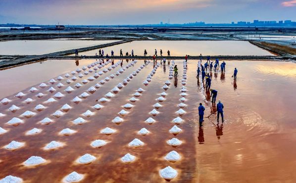 Рабочие выгребают сырую соль из озера Юньчэн