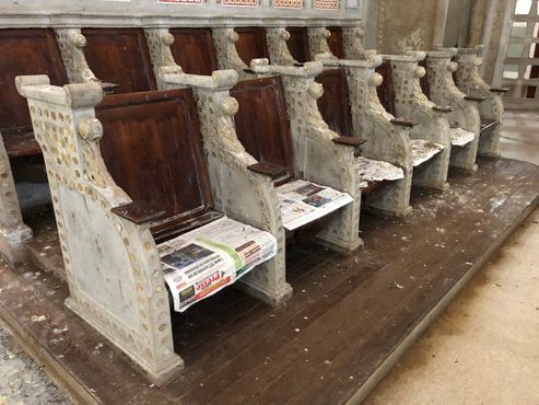 В алтарной части места для хора теперь покрыты старыми газетами и птичьим помётом