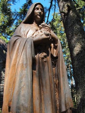 Классическая бронзовая статуя Святой Терезы на территории храма