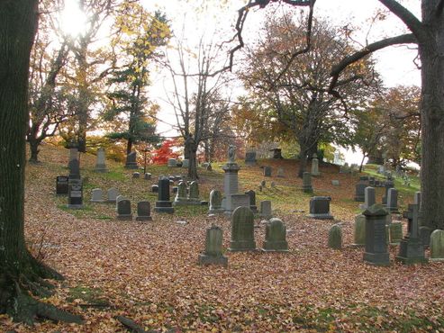 Могилы среди осенней листвы на кладбище Грин-Вуд