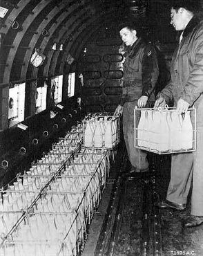 Американские лётчики загружают молоко в самолёт, чтобы доставить его в Западный Берлин, авиабазу Рейн-Майн