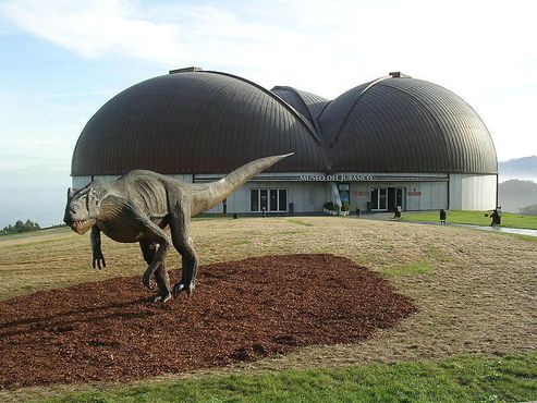 Модель аллозавра в натуральную величину с музеем на заднем плане