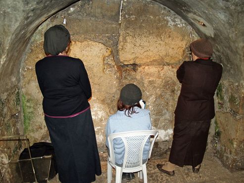 Женщины молятся у ворот Уоррена, ближайшего к святыне места в тоннеле