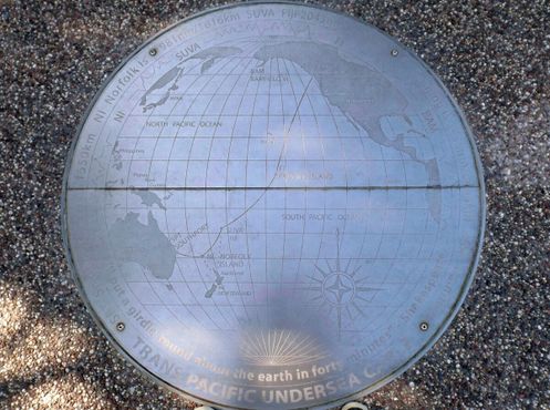 Мемориальный знак на земле, на котором изображён маршрут прокладки кабеля
