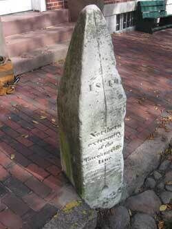 Каменный маркер меридиана недалеко от центра города с надписью: "Северный конец городской меридианной линии"