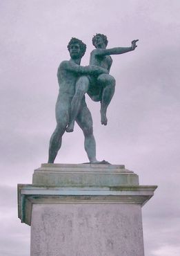 Греческая статуя в дальнем конце цветника