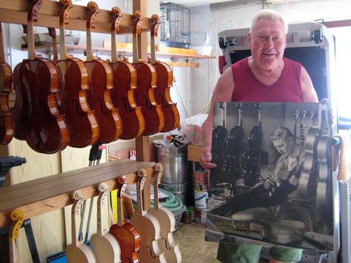 Мастер - скрипач Бруно Вильфер в своей мастерской в Бубенройте, Германия, с фотографией того времени, когда он учился играть на скрипке в Луби, Чехия