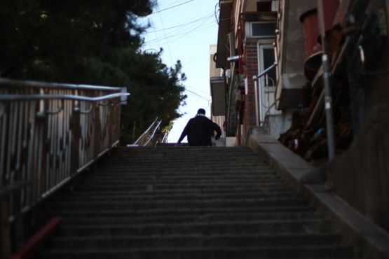 Житель поднимается по лестнице по дороге домой