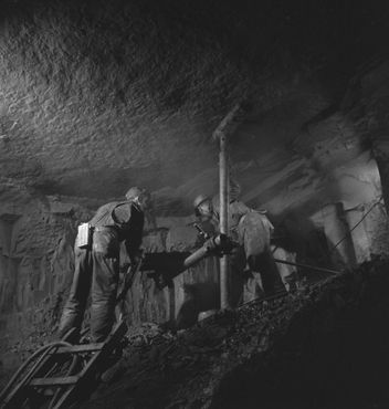 Бурильщик за работой на руднике в Белл Айленд, фотография 1949 года