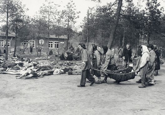 Заключённые выносят тела из бараков, чтобы похоронить их