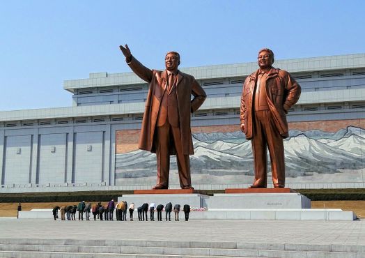 Посетители кланяются в знак уважения к северокорейским лидерам Ким Ир Сену и Ким Чен Ир на Мансуде (холм Мансу) в Пхеньяне, Северная Корея