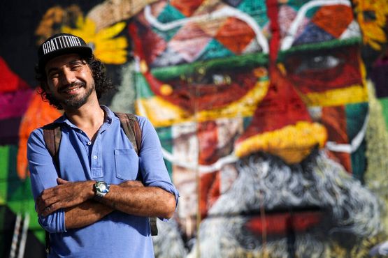 Всемирно известный бразильский художник-граффитист Эдуарду Кобра рядом со своей работой