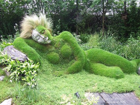 Скульптура спящей женщины из травы