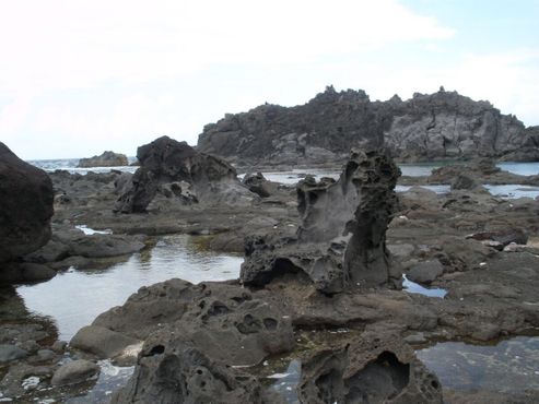 Скальные образования лавы на солевом пруду Оуия