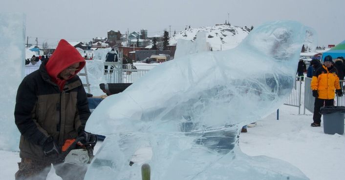 Инук Чарли с помощью бензопилы вырезает статую изо льда, над которой он работает совместно с Кьюзи Керли, 24 марта 2012 года