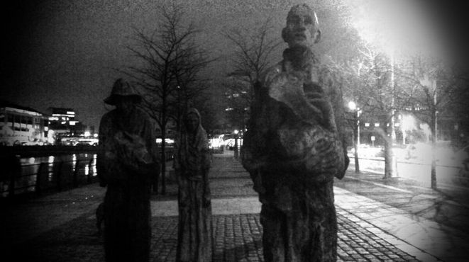 Скульптуры голодающих ночью на черно-белой фотографии