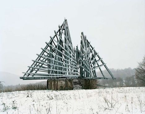 Массивная металлическая конструкция, напоминающая крылья, раскинувшиеся над полем недалеко от города Кореница