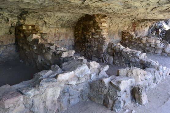 Каменные руины стен индейских домов, расположенных под утёсами