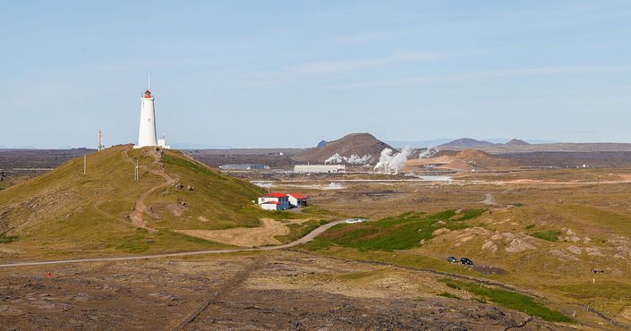 Взгляд от морских скал на долину, маяк Рейкьянесвити, грязевой бассейн и электростанцию
