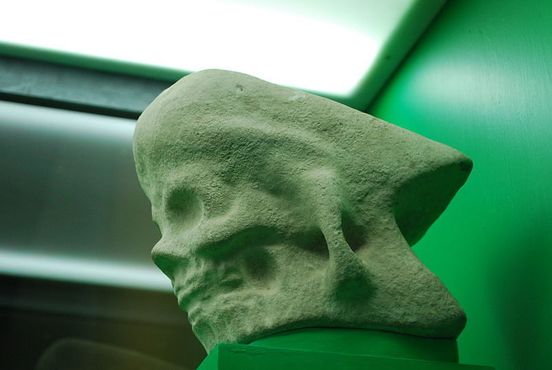 Каменная церемониальная головка топора с изображением человеческого черепа