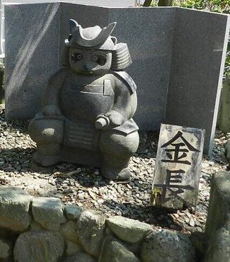 Статуя генерала-тануки Кинчо меньшего размера, в воинском снаряжении и с именной табличкой