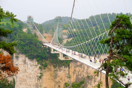 Посетители пересекают самый длинный и высокий в мире стеклянный мост